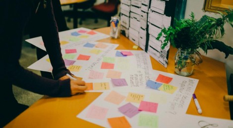 person writing on coloured sticky notes