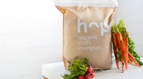 a bag of Hop Compost next to radishes and carrots